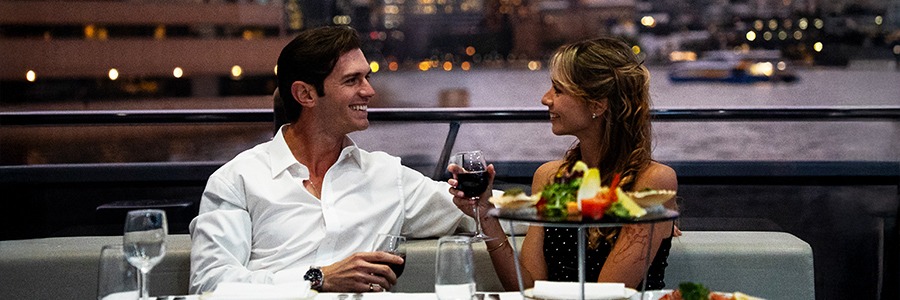 A couple enjoying dinner on the luxury Clearview Glass Boat dinner cruise in Sydney